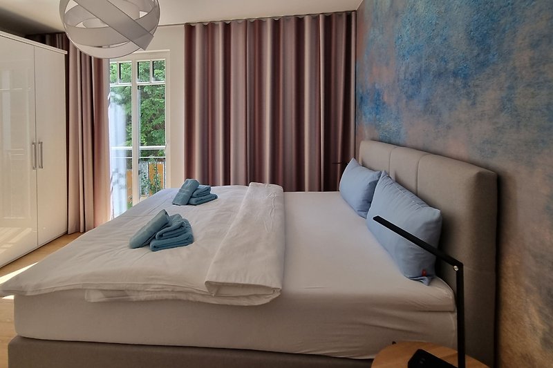 Stilvolles Schlafzimmer mit blauem Bett und Holzmöbeln. Perfekt zum Entspannen.