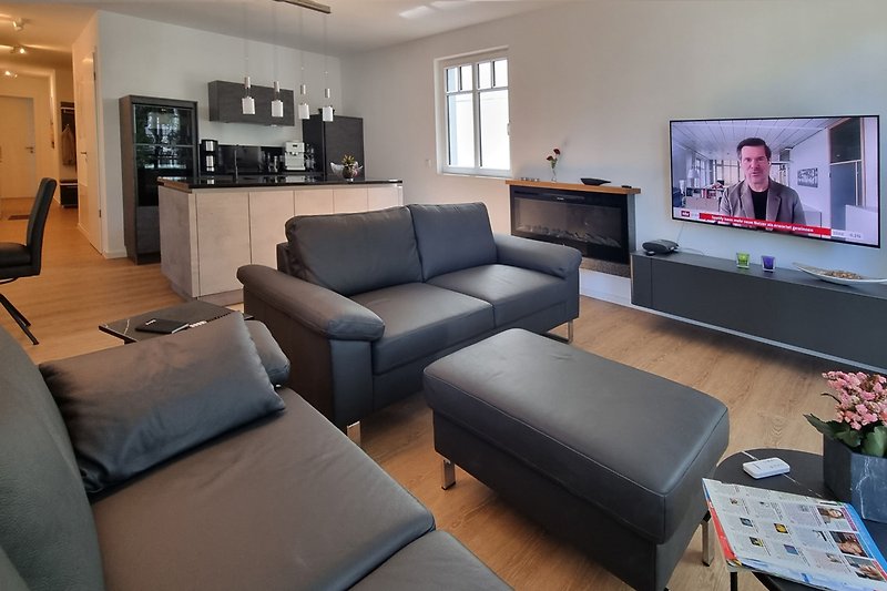 Entspannen Sie auf dem Sofa vor dem Fernseher in dieser stilvoll eingerichteten Wohnung.