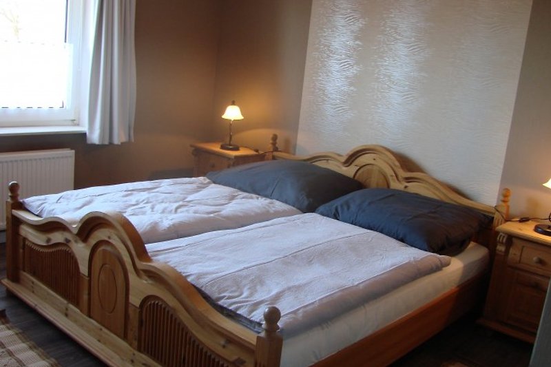 Das ist ein Foto des ersten Schlafraums mit gemütlichem Doppelbett ...