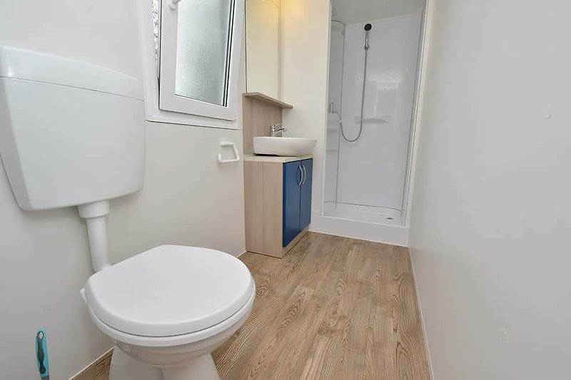 Gemütliches Badezimmer mit lila Akzenten und Holzmöbeln.