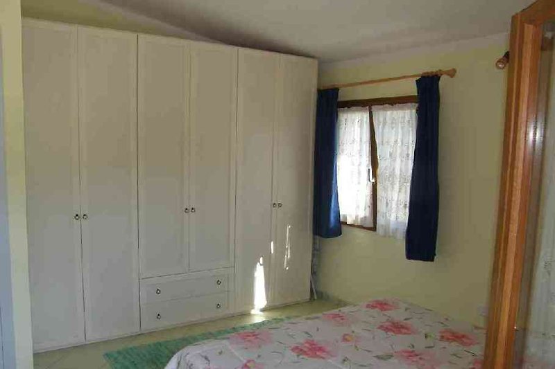 Schlafzimmer mit Doppelbett und großem Schrank