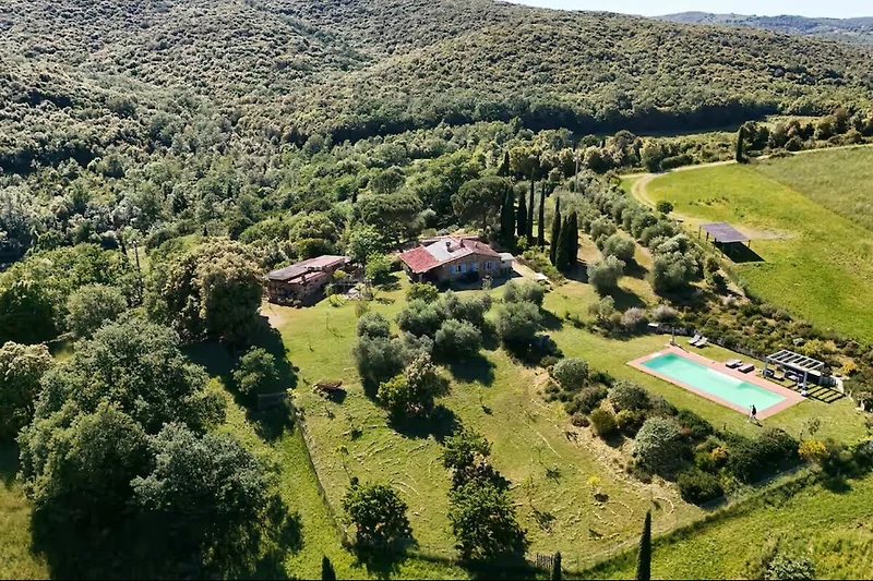 Atemberaubender Ausblick auf Wiesen, Wälder und ein traditionelles Bauernhaus.