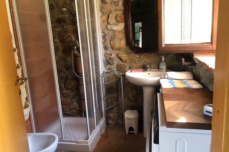 Ein helles Badezimmer mit Fenster, Waschbecken, WC und Bidet.