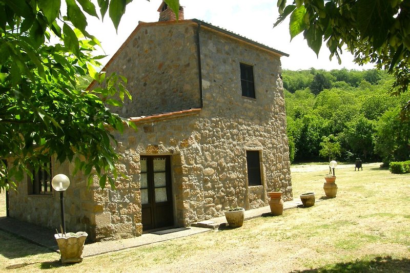 Ländliche kleine Landhaus-Villa mit gepflegtem Garten und weitläufigen Rasenflächen.