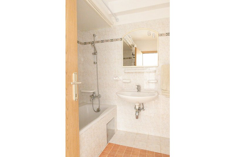Modernes Badezimmer mit Spiegel, Waschbecken und Fliesen.