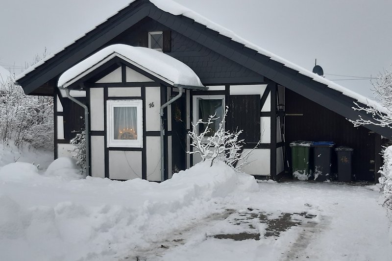 Winterliches Ferienhaus mit schneebedeckter Fassade