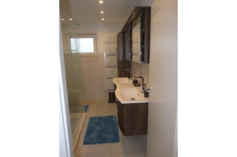 Ein modernes Badezimmer mit Spiegel, Waschbecken und stilvoller Inneneinrichtung.