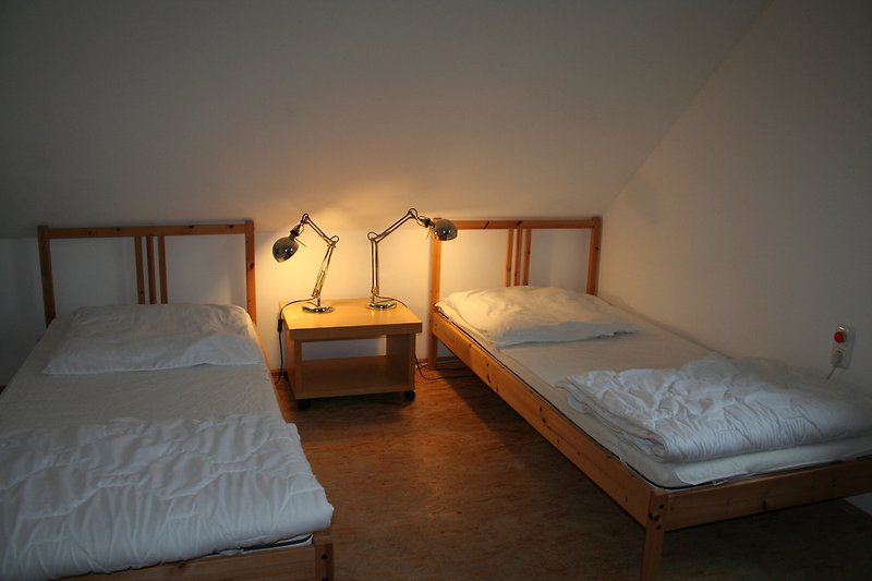 Obje spavaće sobe imaju jednostruke krevete.