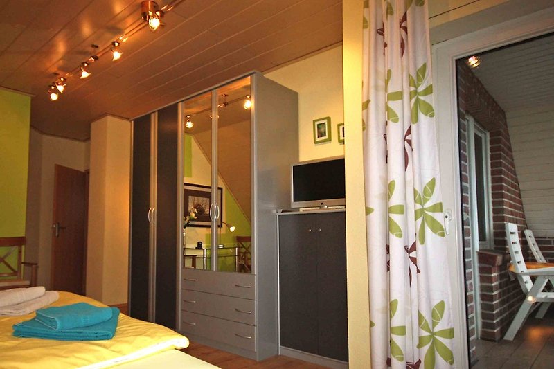 Schlafzimmer S1 mit Kingsize-Bett und Zugang zum Balkon im OG
