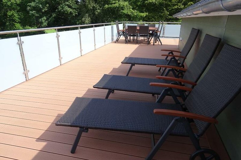 Dachterrasse mit Liegestühlen und Sitzgruppe