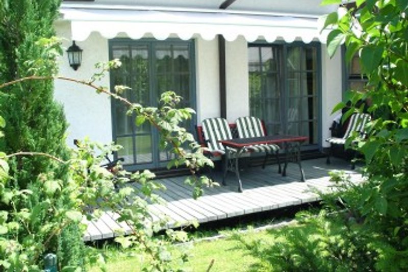 Terrasse mit Gartenstühlen/liegen und elektrischer markise