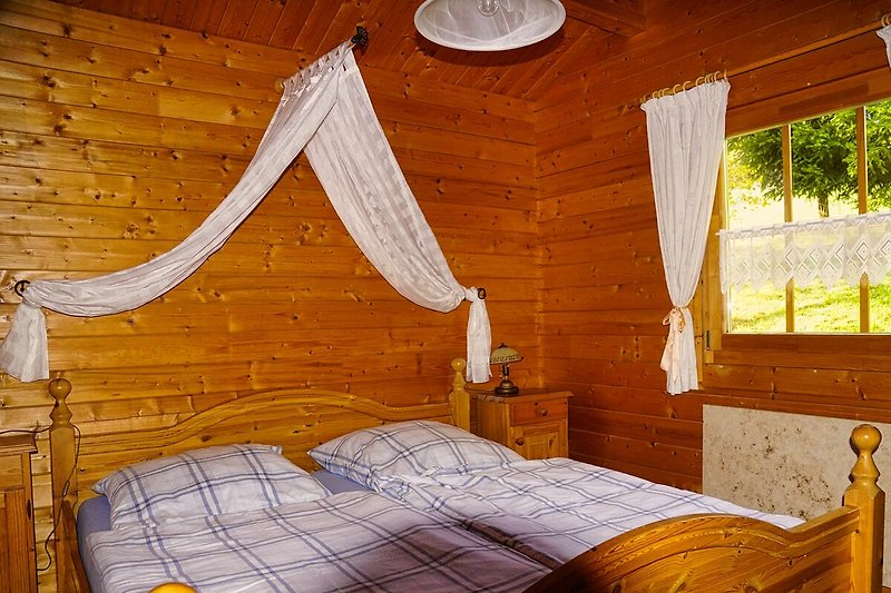 Gemütliches Schlafzimmer mit Holzbett und stilvoller Fensterverkleidung.