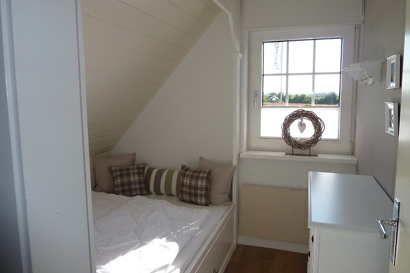 Small upstairs bedroom with alcove bed.
