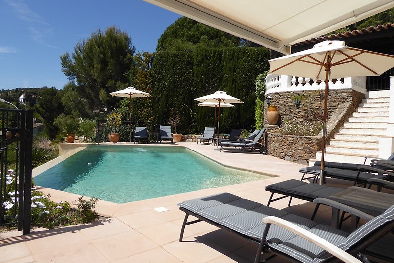 Poolterrasse in Südlage mit Sonnenschirmen und Sonnenliegen