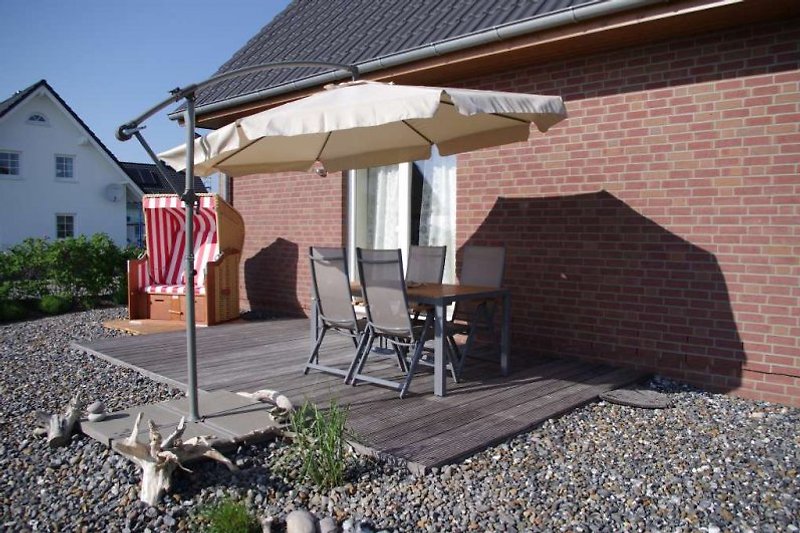 Terrasse mit Sonnenschirm und Strandkorb