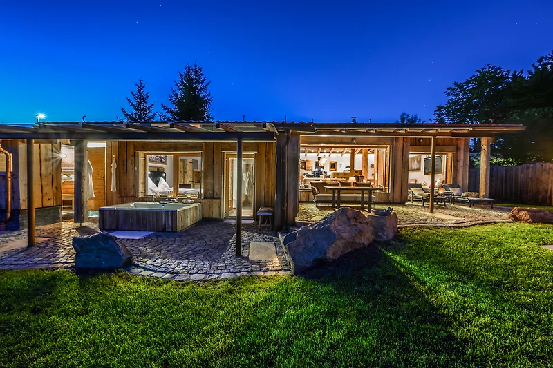 Holzhaus mit überdachter Terrasse und Garten im natürlichen Design.