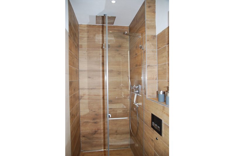 Dusche mit Regenbrause mit Fliesen in moderner Holzoptik
