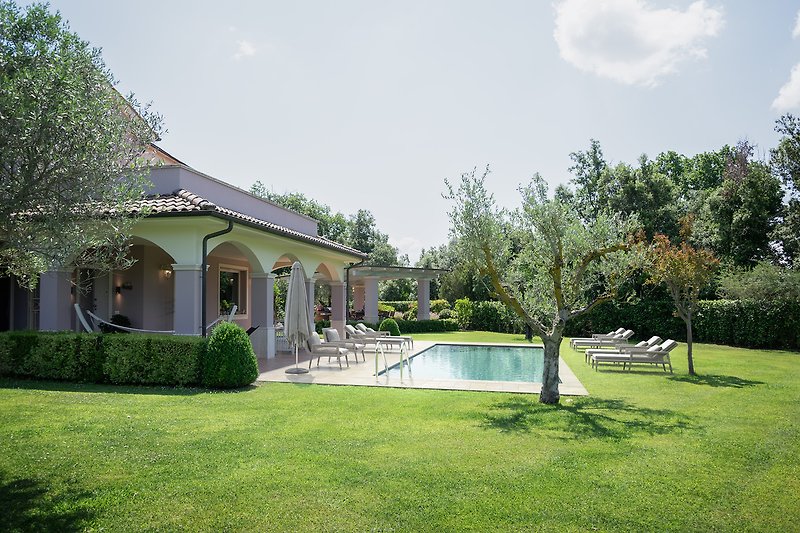 Schönes Haus mit Pool, grünem Garten und entspannter Atmosphäre.