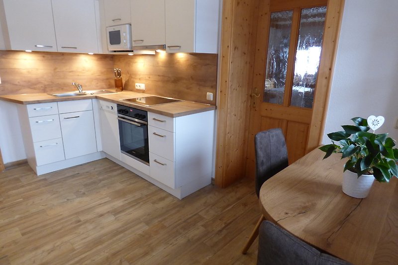 Moderne Küche mit Holzmöbeln, Granitarbeitsplatte und Fensterblick.