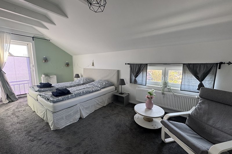 Gemütliches Schlafzimmer mit Bett, Lampen und Kissen.