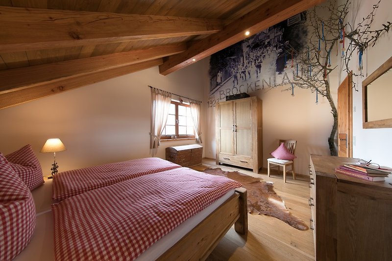 Schlafzimmer mit Fußbodenheizung und aus Altholz gefertigtes Doppelbett