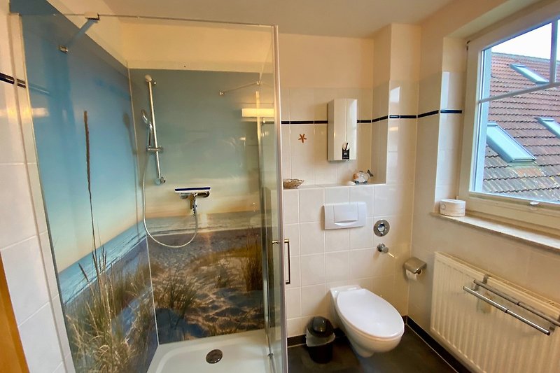 Badezimmer mit Dusche, Waschbecken, Spiegel und Fenster.
