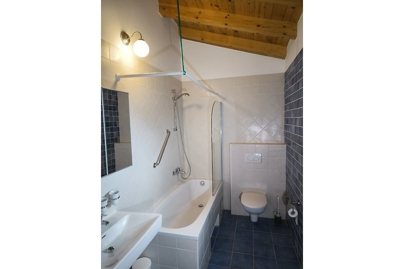 Modernes Badezimmer mit Badewanne, Dusche und Waschbecken.