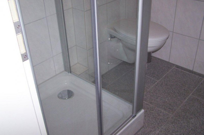 Łazienka z prysznicem w większym mieszkaniu na parterze