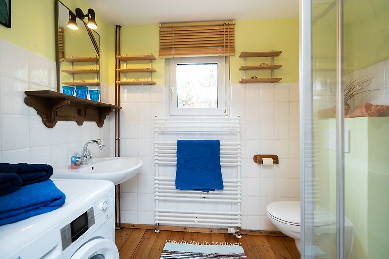 Gemütliches Badezimmer mit blauem Waschbecken und Holzmöbeln.