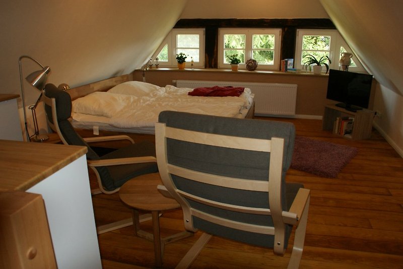 Zimmer oben mit Doppelbett und TV.