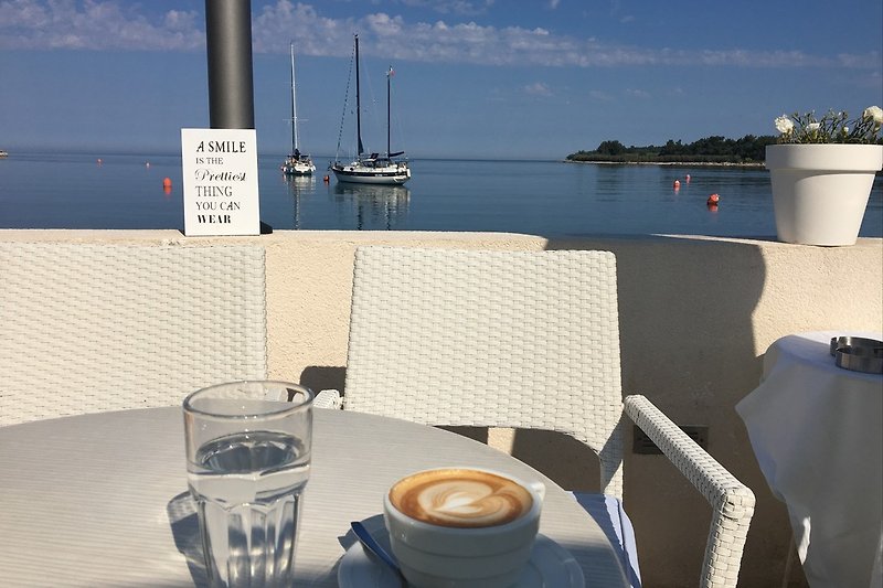 Latte Macchiato in einem Café mit Blick aufs Meer 10 Geheminuten Enfernt