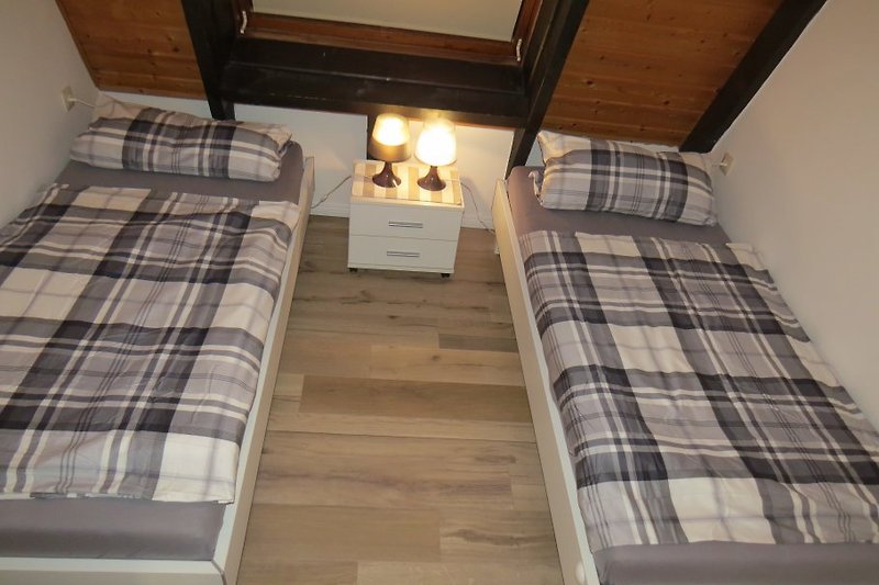 Schlafzimmer mit zwei Einzelbetten im Obergeschoss als Kinderzimmer nutzbar
