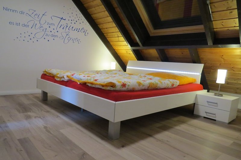 komfortables Doppelbett (2,00m x 2,00m Liegefläche) mit LED-Beleuchtung im Obergeschoss