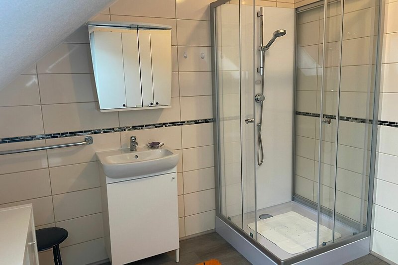 Modernes Badezimmer mit stilvoller Dusche und Glasduschtür.