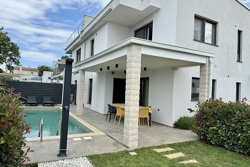 Charmante Veranda mit Pool und Blick auf den gepflegten Garten.