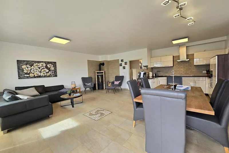Elegante woonkamer met houtdecor, tafel, stoelen en fotolijsten.