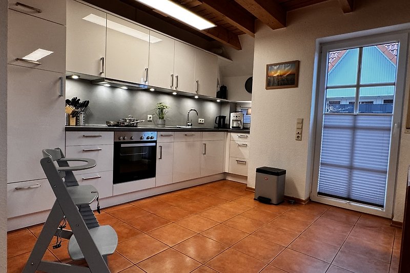 Moderne Küche mit Holzschränken, Küchengeräten und Fenster.