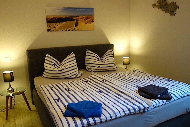 Gemütliches Schlafzimmer mit Holzbett, gelben Kissen und stilvoller Beleuchtung.