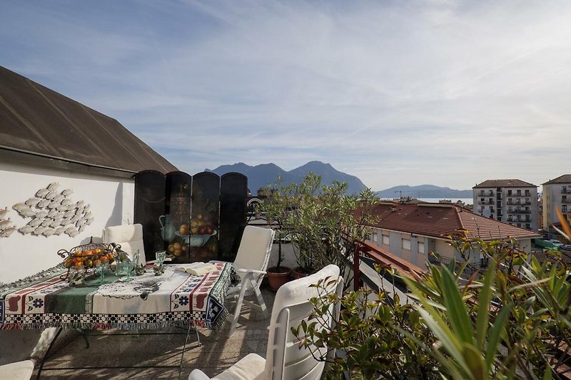 Ca. 10 m² großer Sonnenbalkon mit Blick auf die Dächer von Intra, den See und die gegenüberliegenden Berge
