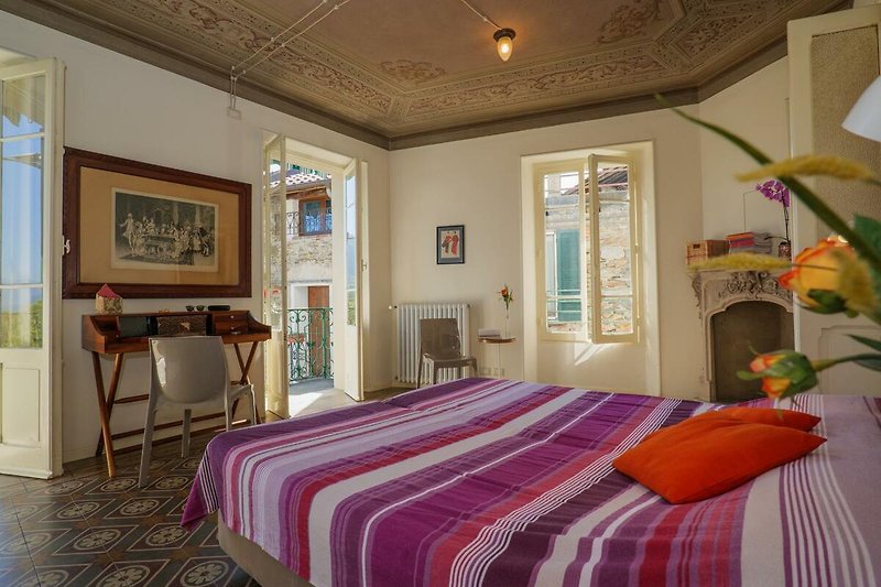 Schlafzimmer mit Doppelbett und Ausgang auf den ca. 25 m² großen Balkon