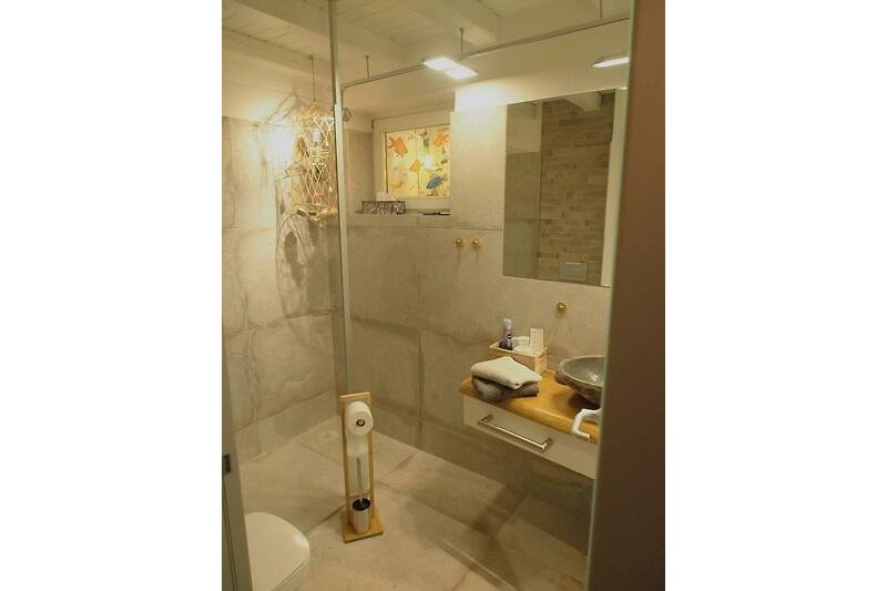 Badezimmer mit ebenerdiger, begehbarer Dusche und Fenster