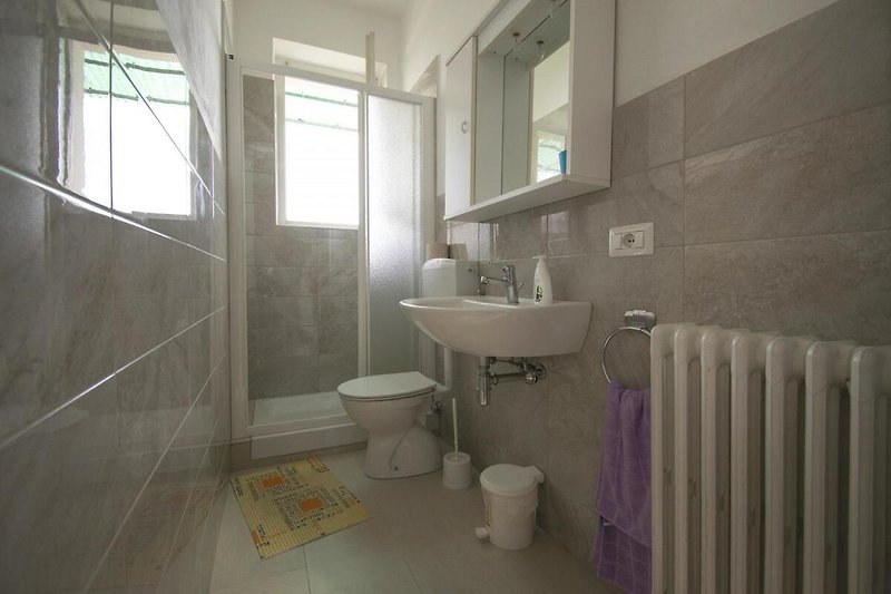 Freundliches Badezimmer mit Dusche und Fenster