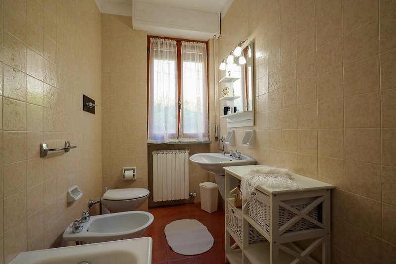 Badezimmer mit Badewanne, Bidet und Fenster