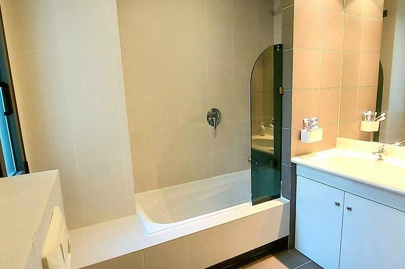 Freundliches Badezimmer mit Badewanne und Fenster
