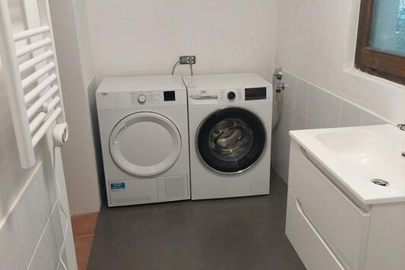 Separater Raum mit Waschmaschine und Wäschetrockner