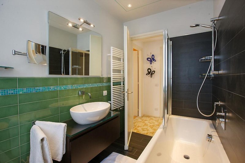 Badezimmer mit Badewanne mit Duschmöglichkeit, Bidet und Fenster