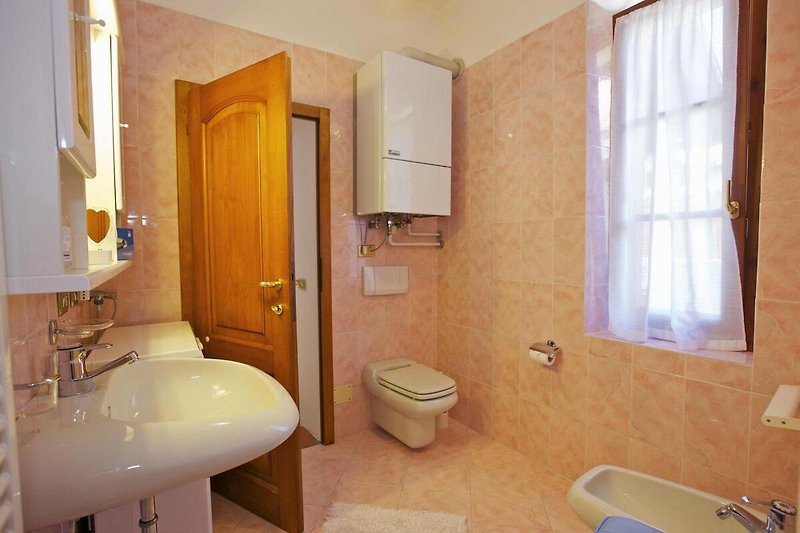Freundliches Bad en suite mit Dusche, Bidet, Waschmaschine und Fenster