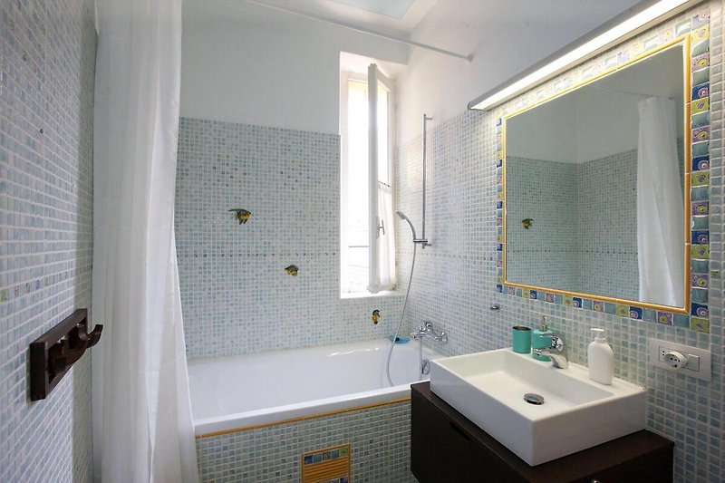 Freundliches Badezimmer mit Badewanne und Sicht auf Cannobio