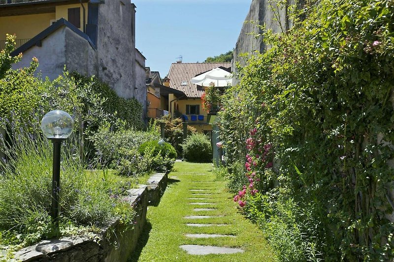 Ca. 200 m² großer idyllischer Garten mit Steinsäulen, Rosen und Palmen