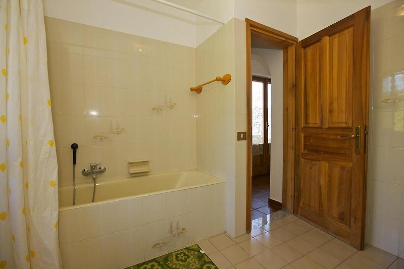 2. freundliches Badezimmer mit Badewanne mit Duschmöglichkeit, Bidet, Fenster und Traumseesicht